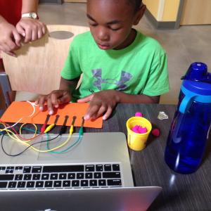 child playing with Makey Makey